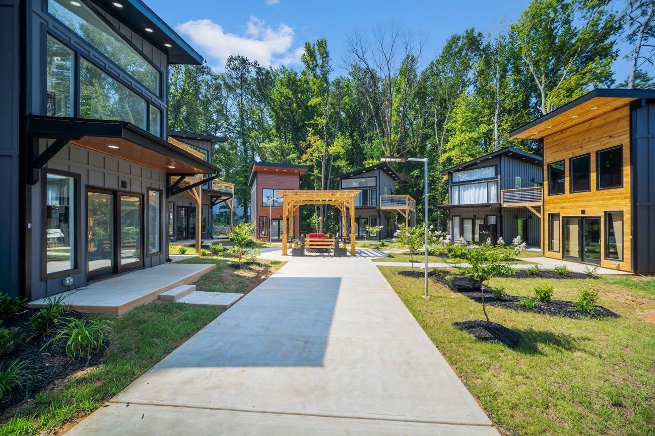 Interior walking path, shade pergola and green space between cottage rows